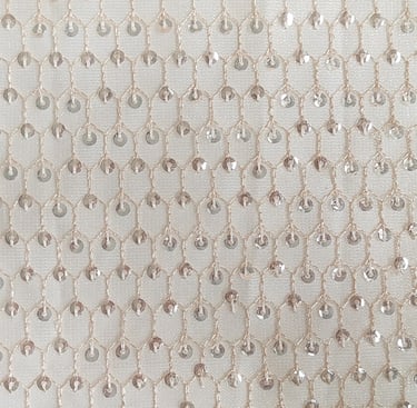 a close up of a white and silver colored beaded fabric with a chain link
