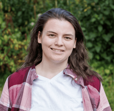 Big Gay Energy host Kaitlynn with long hair and a plaid shirt
