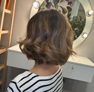 a woman with a short haircut and a balayage color