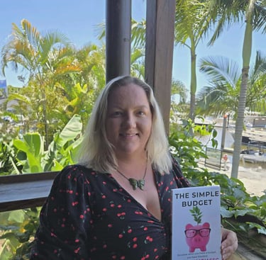 Jackie Matjasec, founder of The Simple Budget, holding a copy of The Simple Budget book.