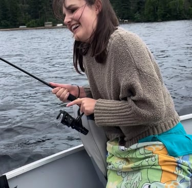 jeune fille qui peche avec la famille sur bateau au lac en Outaouais