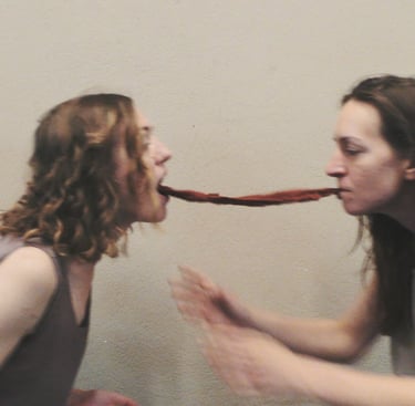 Two dancers connected by a red scarf between their mouths – film still from Being Together by Tina Bikic