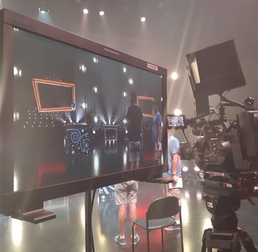 Monitor displaying a live show recording with bright stage lighting and production setup