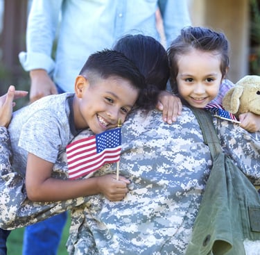 a soldier soldier is holding a teddy bear