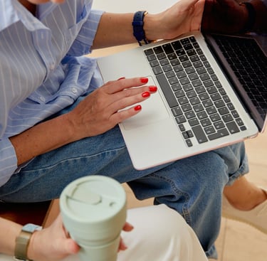 2 femmes assises, l'une avec un café, l'autre avec un ordinateur portable sur les genoux