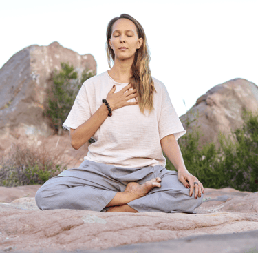 woman meditating with hand on heart