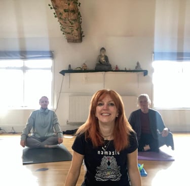 Yoga teacher Katie sat with her students smiling
