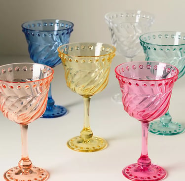 Elegant set of colorful hobnail wine glasses with swirl patterns in pink, yellow, blue, and teal.