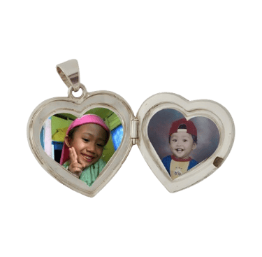 Open heart-shaped silver locket pendant featuring two colorful photos of young children.