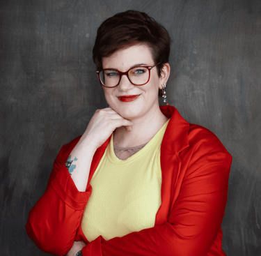 ein Photo von Swana Schuchmann mit rotem Blazer. Sie lächelt Dich an.