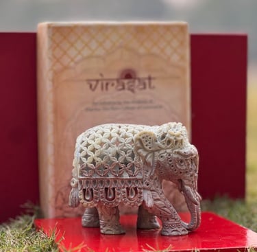a small elephant statue sitting on a red book