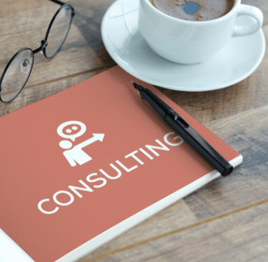 The image of the notebook titled "CONSULTING" with glasses, a pen, and a coffee cup.