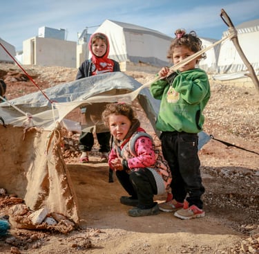 enfants pauvres réfugiés jouent dans terrain vague et boueux