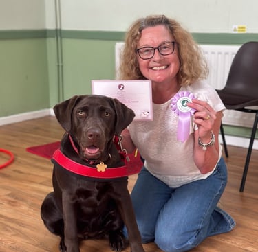 Chocolate Labrador & handler smiling after passing their KC puppy foundation dog training class