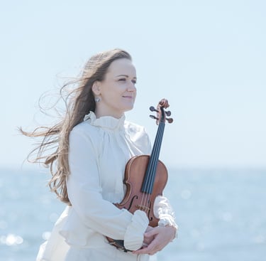 Portrait of violinist Zydre by the Japanese seaside, with hair flowing in the wind.