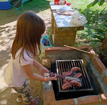 Criança, ajudando no preparo de um churrasco no acampamento