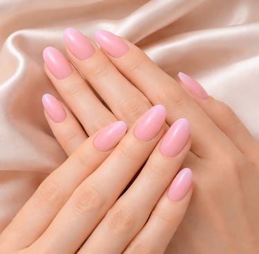 Elegant almond-shaped pink gel manicure on hands resting over soft silk fabric.