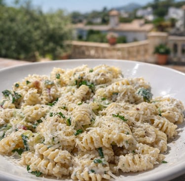 Creamy radiatori pasta with parmesan cheese and herbs served on a sunny terrace in Italy.