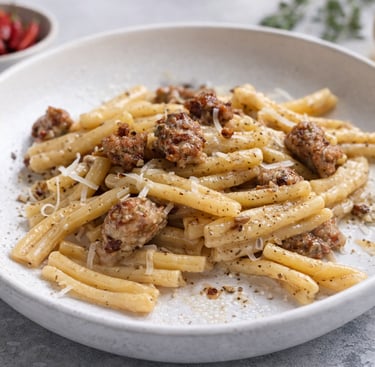 Casarecce pasta with Italian sausage with creamy gorgonzola sauce in a white bowl.