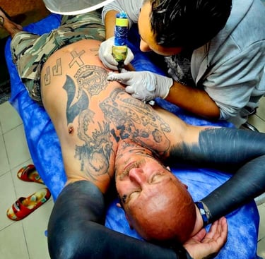 Tattoo artist working on client arm in Hurghada”