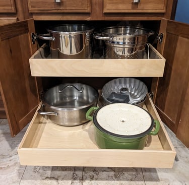 Kitchen cupboard pullouts holding pots and pans.