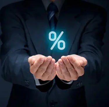 En affärsman i mörk kostym håller fram sina händer med en lysande procentsymbol.