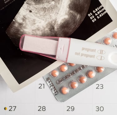 A positive pregnancy test, ultrasound photo, and birth control pills on a calendar.