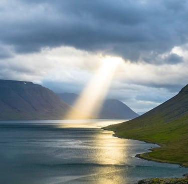 sun beam coming through clouds onto ocean