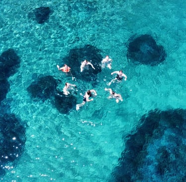 a group of people swimming in the ocean near la Canée