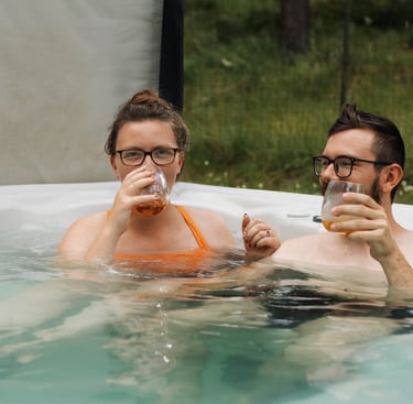 a man and woman in a hot tub drinking whiskey