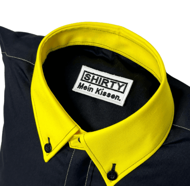 a black shirted pillow with a yellow collar and label