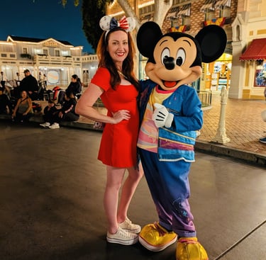Woman taking picture with Mickey Mouse on Main Street USA at Disneyland. 