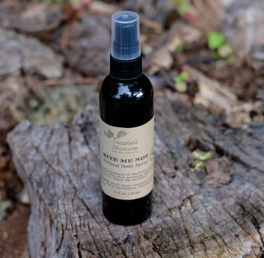 black spray bottle of liquid on a tree stump