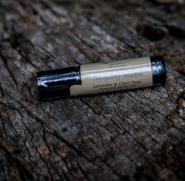 body oil in black vial on a tree stump