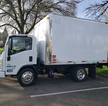 a white truck with a white boxy truck in the background