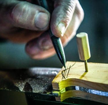 un coutelier qui dessine sur un bloc de bois