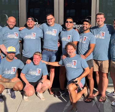 a group of people standing in front of a building wearing matching tshirts