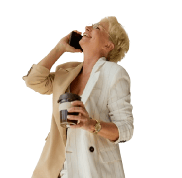 a woman in a white coat and a cell phone- smiling as she talks to an ai voice assistant.