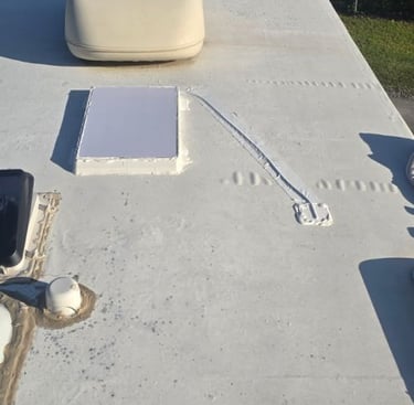White rubber RV roof showing a custom mounted Starlink dish.