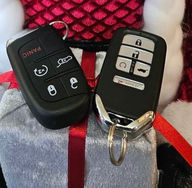 Two Honda key fobs placed on a Christmas-themed background