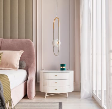 Modern pink velvet bed next to a white three-drawer nightstand and elegant gold pendant lighting.