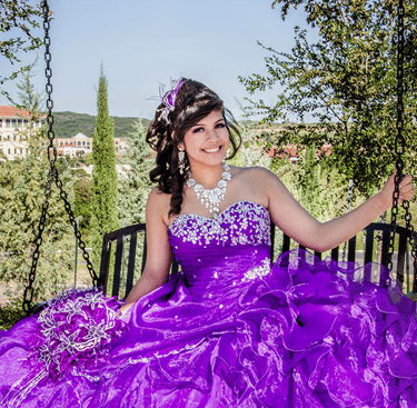 a woman in a purple quinceanera dress sitting on a bench