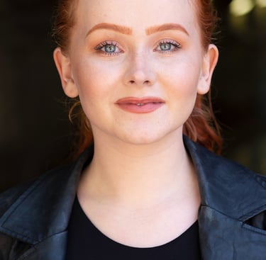 a woman with red hair and a black jacket