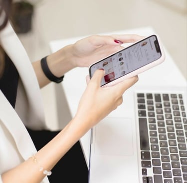 Mujer profesional usando un teléfono inteligente mientras trabaja en una computadora portátil