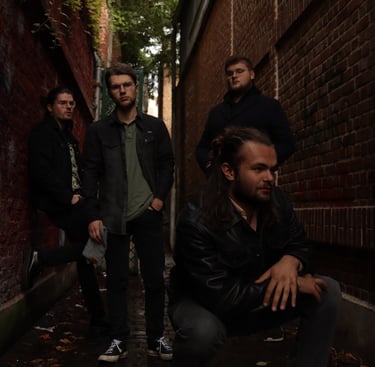  Le groupe Rush On Mars regardant à l'horizon sur un fond de brique.