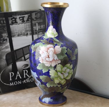 a blue vase with a flower on it