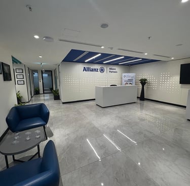 Modern Allianz Partners corporate office reception area with blue armchairs and marble floors.