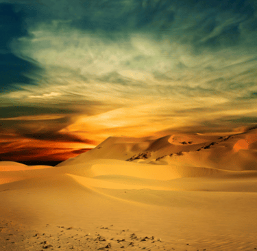 a person walking through a desert landscape with a sunset