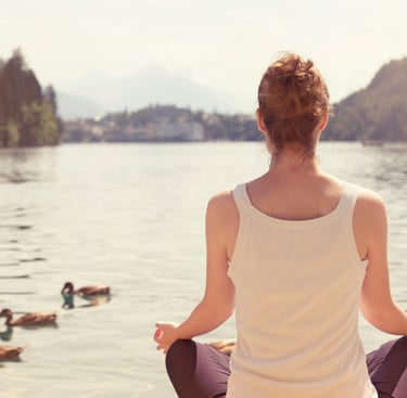 a woman sitting in a lotus position with her eyes closed