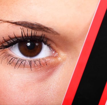 a woman with a red eyeliners and mascara brush